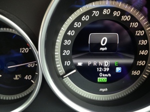Speedometer on Mercedez rental car.  Not sure why there is a coffee cup.